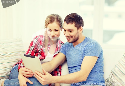 Image of smiling couple with tablet pc computer at home