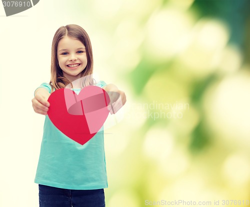 Image of smiling little girl giving red heart