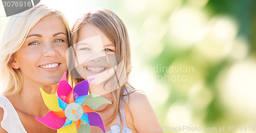 Image of happy mother and little girl with pinwheel toy