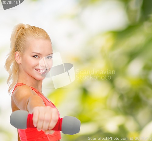 Image of smiling beautiful sporty woman with dumbbell