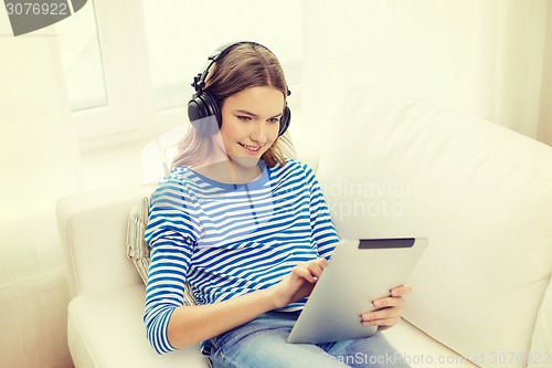 Image of girl with tablet pc and headphones at home