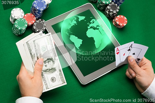 Image of casino poker player with cards, tablet and chips