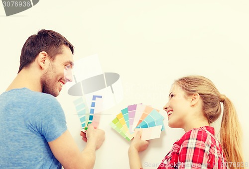 Image of smiling couple looking at color samples at home