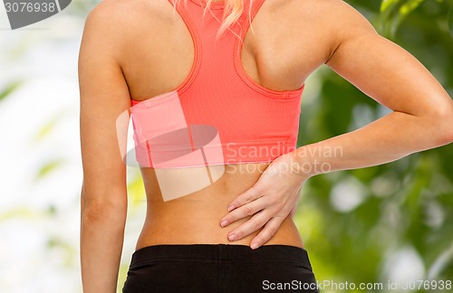 Image of close up of sporty woman touching her back