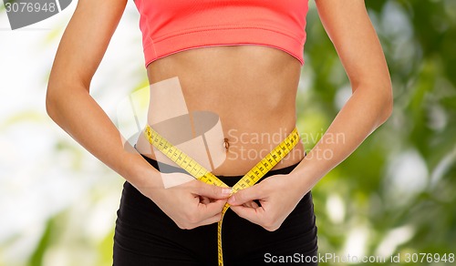 Image of close up of female hands measuring waist