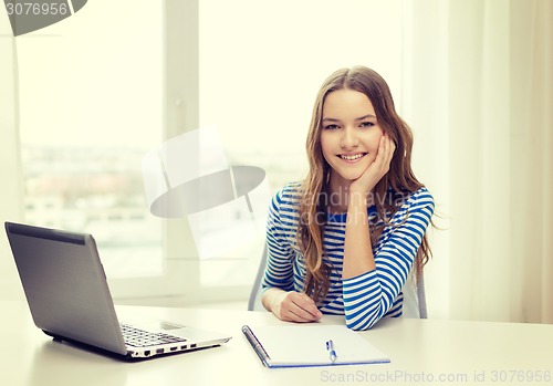 Image of smiling teenage girl laptop computer and notebook