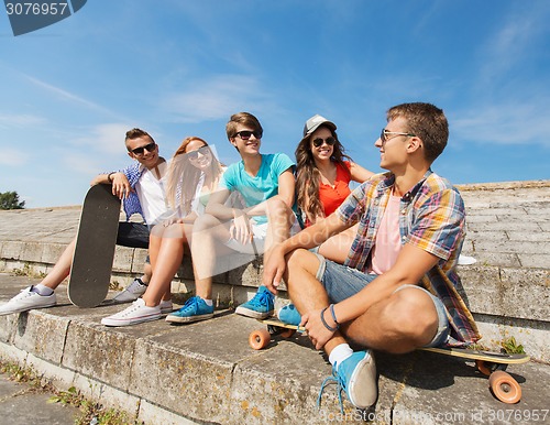 Image of group of smiling friends sitting on city street