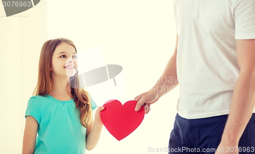 Image of smiling little girl and father holding red heart