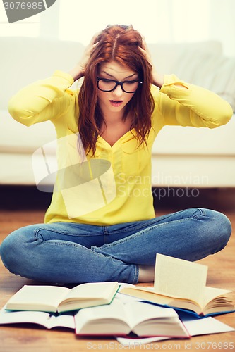 Image of smiling student girl reading books at home