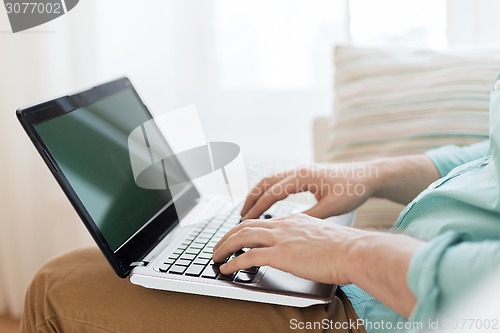 Image of close up of man working with laptop at home