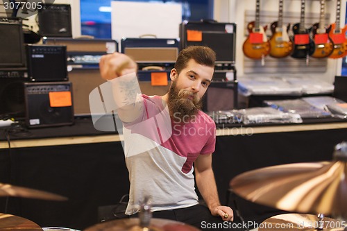 Image of male musician playing cymbals at music store