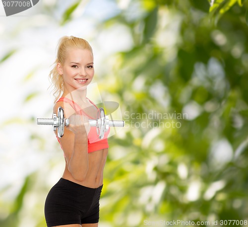 Image of young sporty woman with heavy steel dumbbell