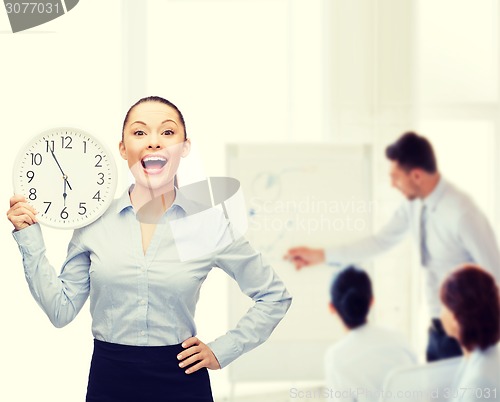 Image of attractive businesswoman with wall clock