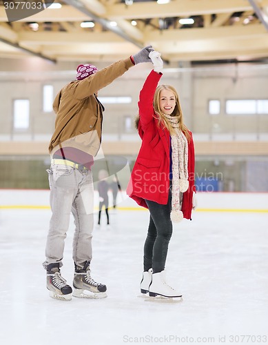 Image of happy couple holding hands on skating rink