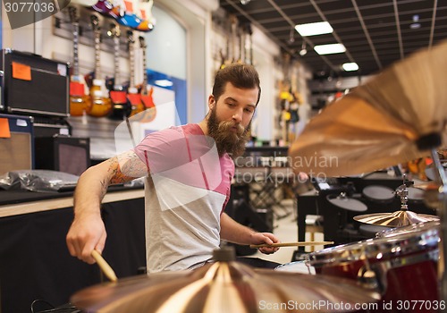 Image of male musician playing cymbals at music store