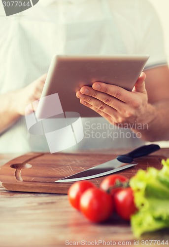 Image of closeup of man pointing finger to tablet pc