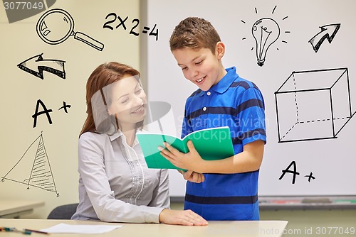 Image of school boy with notebook and teacher in classroom