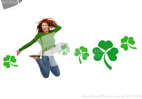 Image of smiling teenage girl jumping in air with shamrock