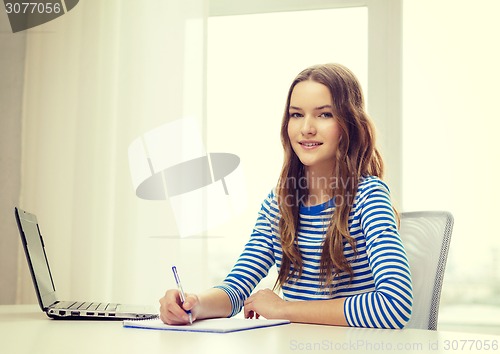 Image of smiling teenage girl laptop computer and notebook