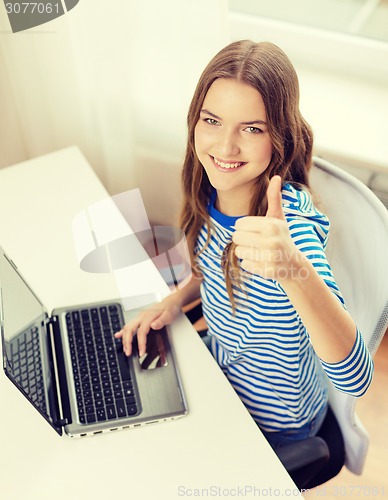 Image of smiling teenage gitl with laptop computer at home