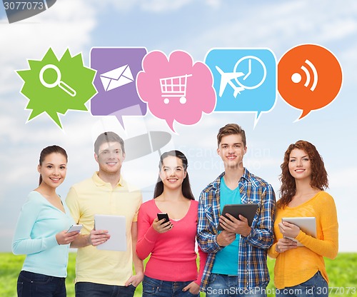 Image of group of teenagers with smartphones and tablet pc