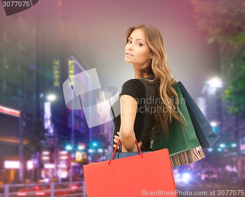 Image of young happy woman with shopping bags over city