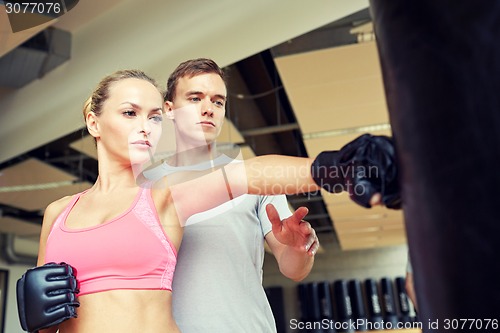 Image of woman with personal trainer boxing in gym