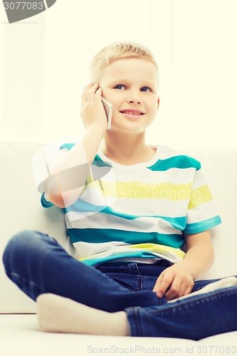 Image of smiling little boy with smartphone at home