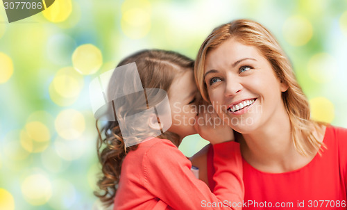 Image of happy daughter whispering gossip to her mother