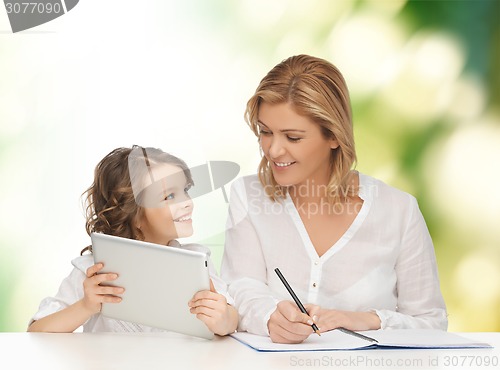 Image of woman with notebook and girl holding tablet pc 