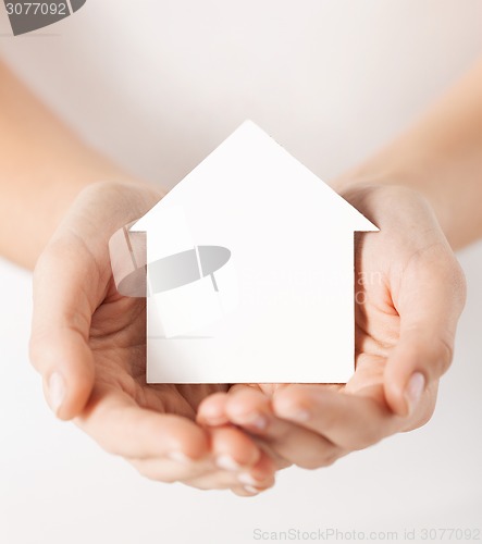 Image of hands holding white paper house