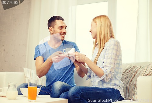 Image of man giving his girlfriend or wife cup of coffee