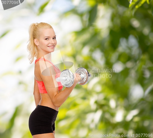 Image of young sporty woman with heavy steel dumbbell