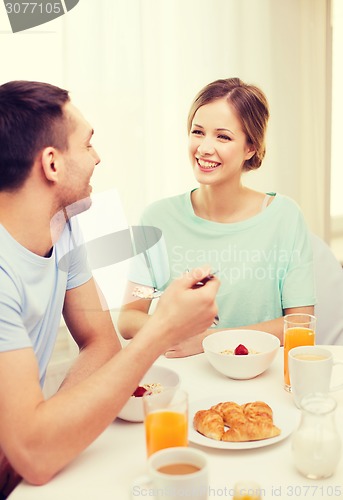 Image of smiling couple having breakfast at home