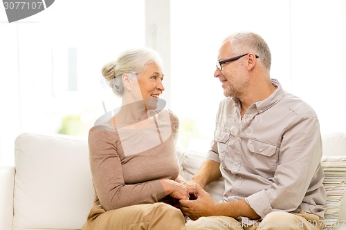 Image of happy senior couple hugging on sofa at home