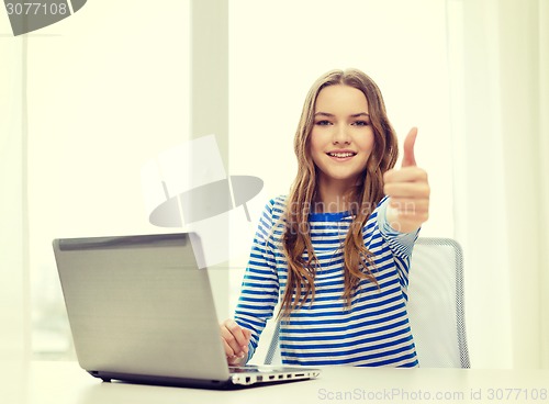 Image of smiling teenage gitl with laptop computer at home