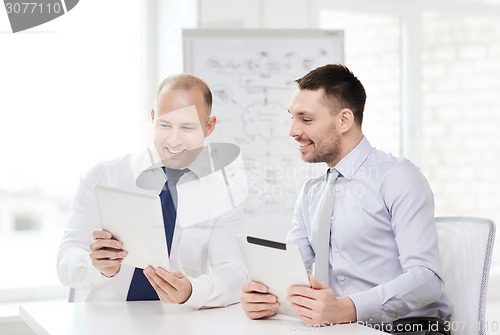 Image of two smiling businessmen with tablet pc in office