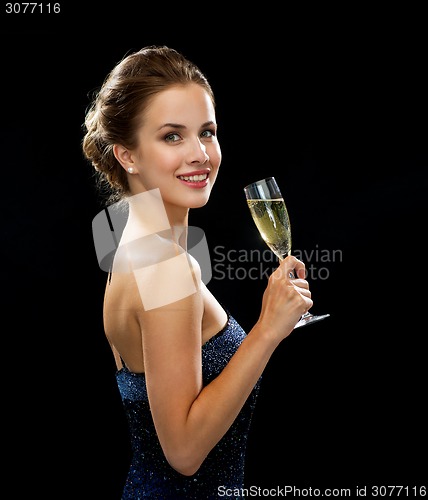 Image of smiling woman holding glass of sparkling wine