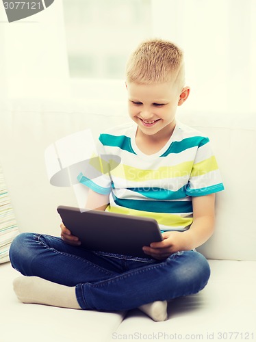 Image of smiling boy with tablet computer at home