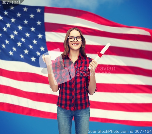 Image of smiling female student in eyeglasses with diploma