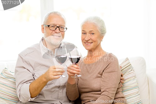 Image of happy senior couple with glasses of red wine