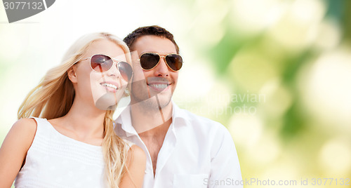 Image of happy couple in shades over green background