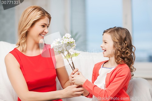 Image of happy mother and daughter with flowers