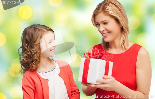 Image of happy mother and daughter with gift box