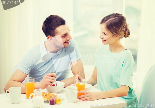 Image of smiling couple having breakfast at home