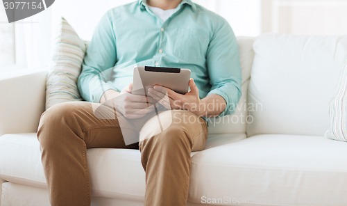 Image of close up of man with tablet pc computer at home