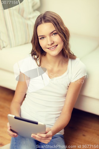 Image of smiling teenage girl with tablet pc at home