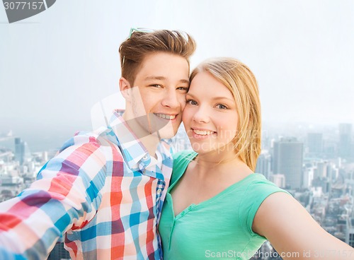 Image of smiling couple with smartphone in city background