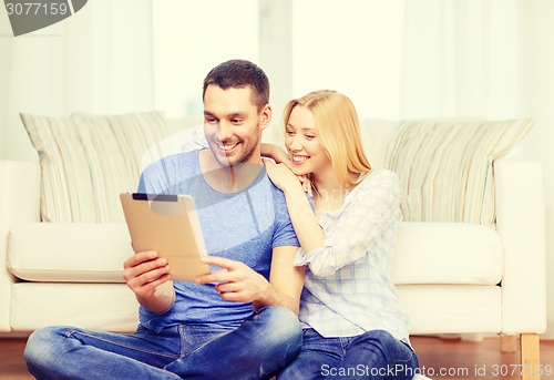 Image of smiling happy couple with tablet pc at home