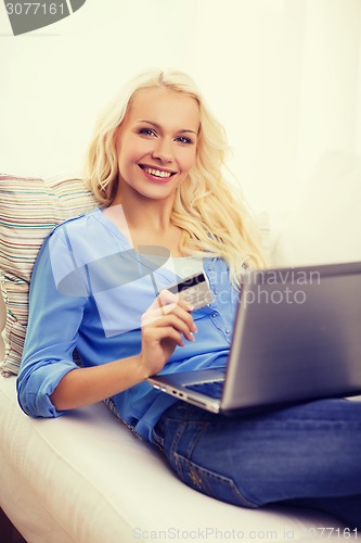 Image of smiling woman with laptop computer and credit card